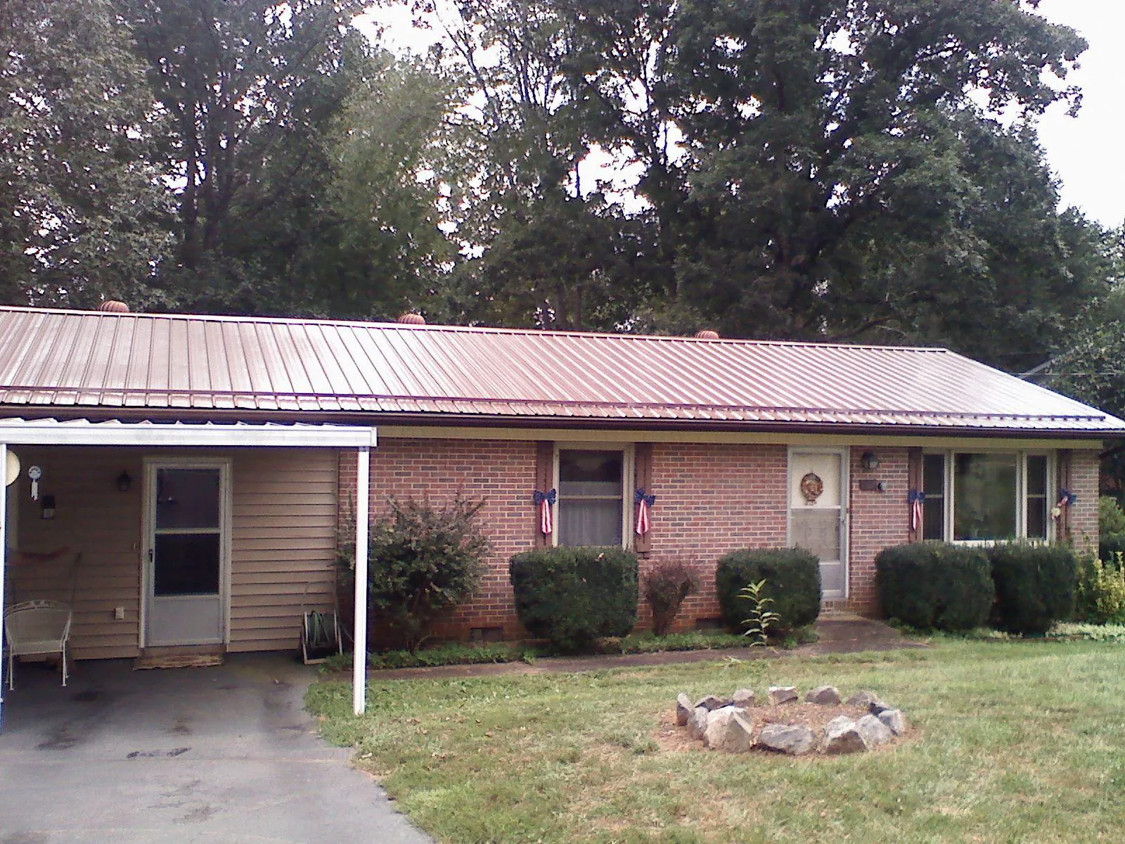 Bronze metal roof and carport on a brick ranch home — Roof Repair work by our crew in Pine Bluff
